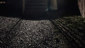 Talo, jossa on kuisti, portaat, jotka johtavat ovelle, ja pieni puutarha-alue.