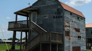 A rustic barn with a wooden balcony and a metal roof. - Barn 2 @ Yellow Rose Canyon (Mount Enterprise)
