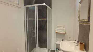 Een douche, een haardroger, handdoeken, toiletpapier