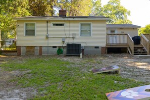 A two-story house with a front deck and a covered porch. - Cute n' Comfy Capers (Columbia)
