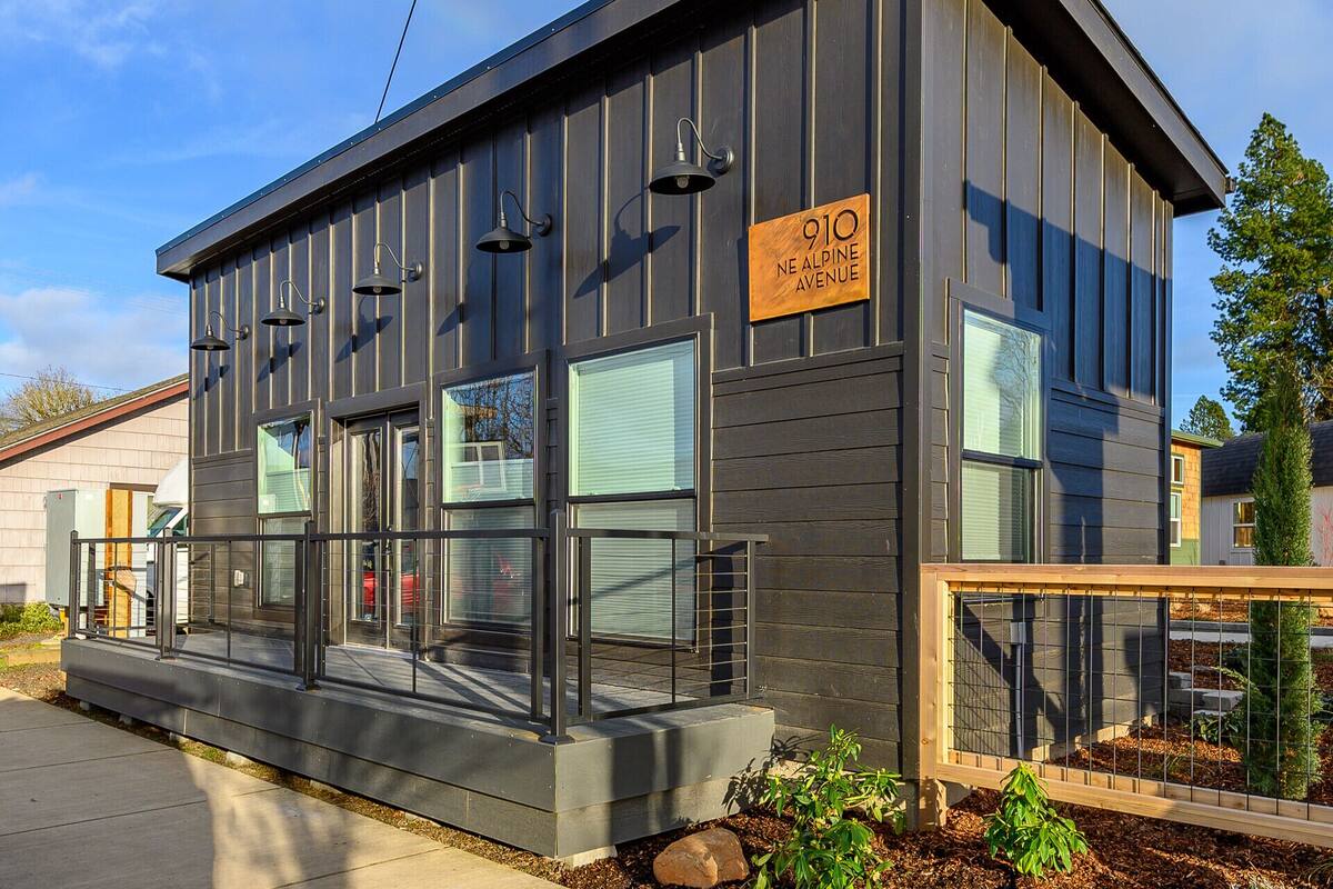A modern building with a sign reading "910 NE ALPINE AVENUE".