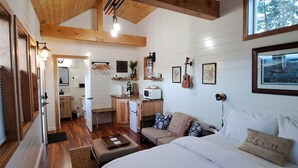 Una habitación acogedora con cama, una kitchenette pequeña y un comedor.