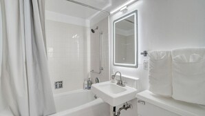 Ein modernes Badezimmer mit Badewanne, Waschbecken und Spiegel.