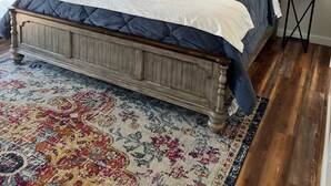 Een slaapkamer met een houten bed, een kamerbreed tapijt en een plafondventilator.