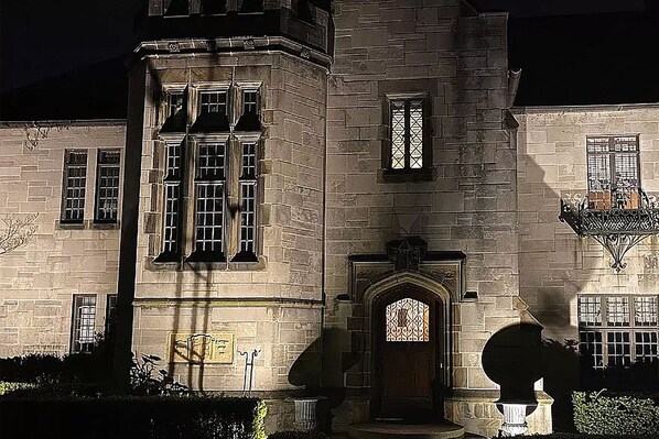 Step into this historic building through its grand entrance, featuring a large door and decorative archway, with tall windows and a charming balcony.