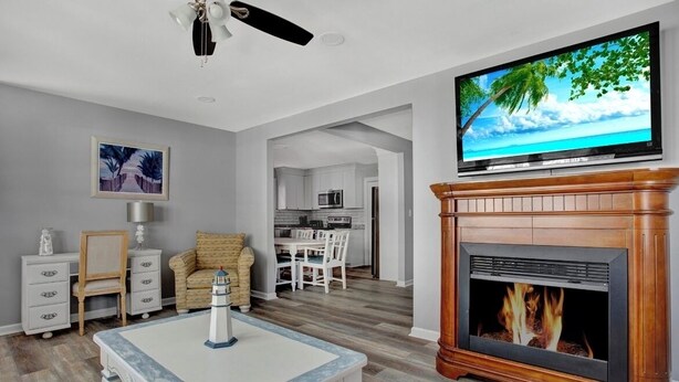 Una sala de estar con chimenea, televisor y comedor.
