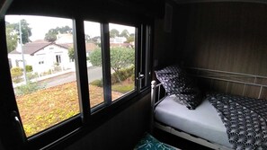 Cozy retreat with a single bed, window offering views of the surrounding neighborhood.