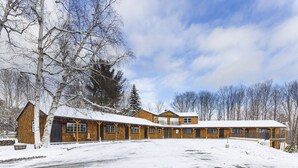 A large, multi-story lodge with a symmetrical facade, multiple windows, and a covered parking area.