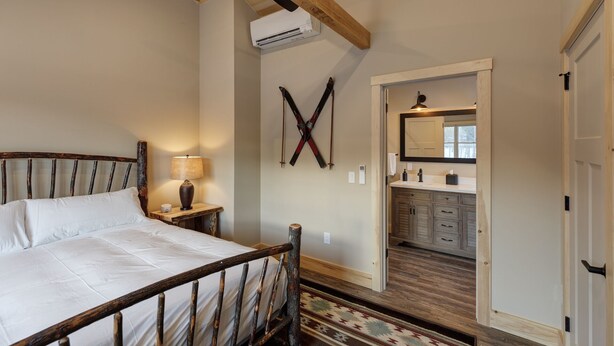 Ein Schlafzimmer mit einem hölzernen Bettgestell, einer Nachttischlampe und einem Skiständer an der Wand.