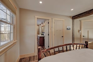 Un dormitorio con cabecera de madera, un ventanal y vistas al exterior.