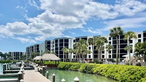 Un port de plaisance avec des bateaux amarrés, un canal et des bâtiments modernes dotés de balcons.