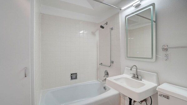 A modern bathroom with a bathtub, a sink, and a shower.
