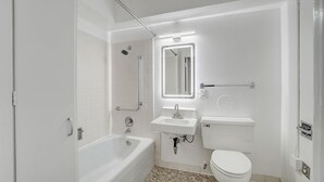 Ein modernes Badezimmer mit Badewanne, Waschbecken, Toilette und Dusche.