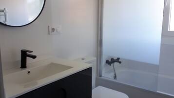 Een bad, een haardroger, handdoeken, toiletpapier