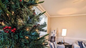 A cozy living room with a decorated Christmas tree, a sofa, and a coffee table.