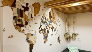 Un mural de mapa del mundo con techo de madera y un cojín verde con texto.