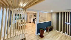 Una cocina moderna con vigas de madera, un comedor con sillas y una planta en maceta.
