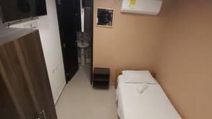 A small, well-lit room with a bed, a wardrobe, a sink, and a television. - CL-11 Habitación en Getsemaní con wifi (Cartagena)