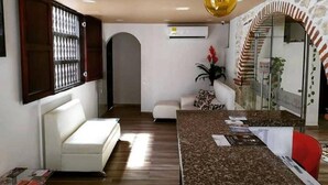 A modern living room with a white sofa, a coffee table, and a decorative archway. - CL-11 Habitación en Getsemaní con wifi (Cartagena)