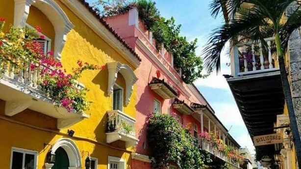 A street with colorful buildings, balconies with flowers, and a clear sky. - CL-11 Habitación en Getsemaní con wifi (Cartagena)