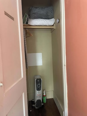 A small, narrow room with a bed at the top, a whiteboard on the wall, and a cleaning device on the floor. - Few blocks  from the best uptown shops and restaurants (St. Augustine)