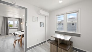 A modern kitchen with a built-in stove, a window with a view, and a dining area with a table and chairs.