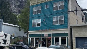 Situated in a scenic mountain location, this hotel offers a charming two-story facade with a flat roof and a prominent chimney.