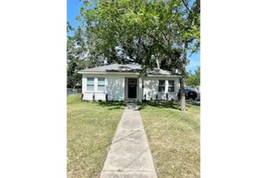 Welcome to a charming single-story home with a front entrance and beautifully manicured lawn.