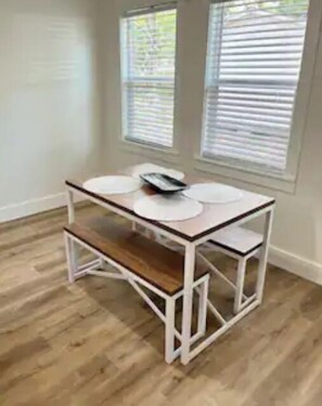 Situated near a window, this room features a compact table and a wooden bench.