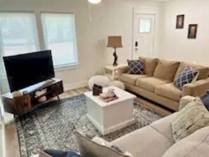 Relax in this inviting living room with a flat-screen TV, comfortable sofa, and stylish coffee table.