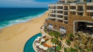 A resort with a pool, beach, and ocean view.
