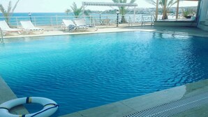 En swimmingpool med liggestole og en redningsbøje.
