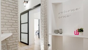 Un intérieur moderne avec un mur en briques, une porte en verre et une pancarte indiquant « Bienvenue chez vous ».