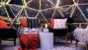 A cozy seating area with a chair, a blanket, and a candle.