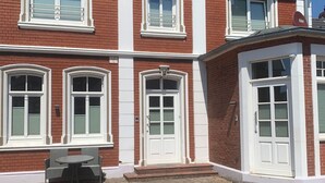 Una casa de ladrillo de dos pisos con ventanas de marco blanco y una puerta principal.