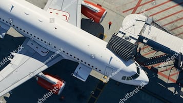 An airplane parked at a gate with visible jet bridges and ground service equipment.