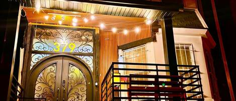 A building with a prominent entrance featuring a decorative glass door and a staircase leading up to it.