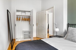 A bedroom with a bed, a wardrobe, a bedside table with a lamp, and a door leading to another room. - Premium Penzing 1BR w/ Elevator at U3  Hütteldorfer, by Blueground (Vienna)