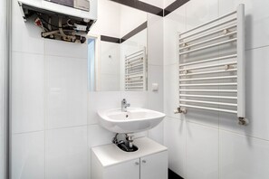 A modern bathroom with a white sink, a mirror, and a towel rack. - Premium Penzing 1BR w/ Elevator at U3  Hütteldorfer, by Blueground (Vienna)