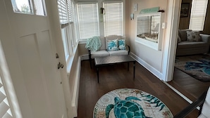 Une pièce dotée d’une grande fenêtre, d’un ventilateur de plafond, d’un canapé, d’une table basse et d’un tapis à motifs.