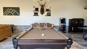 A pool table with a mounted deer head decoration, a sofa, and a chandelier. - Explore like a local with access to everything Flagstaff has to offer (Flagstaff)
