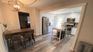 A modern kitchen with a central island, bar stools, and a dining area with a wooden table and chairs. - Explore like a local with access to everything Flagstaff has to offer (Flagstaff)