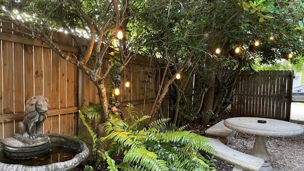 A garden with a stone fountain, a stone bench, and string lights. - Old Town "Gem", Near Historic Downtown Saint Augustine (St. Augustine)