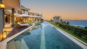 A modern hotel with a pool, outdoor seating, and a view of the ocean. - Oceanview 4BR Villa,Infinity Pool in East Bali (Candidasa)