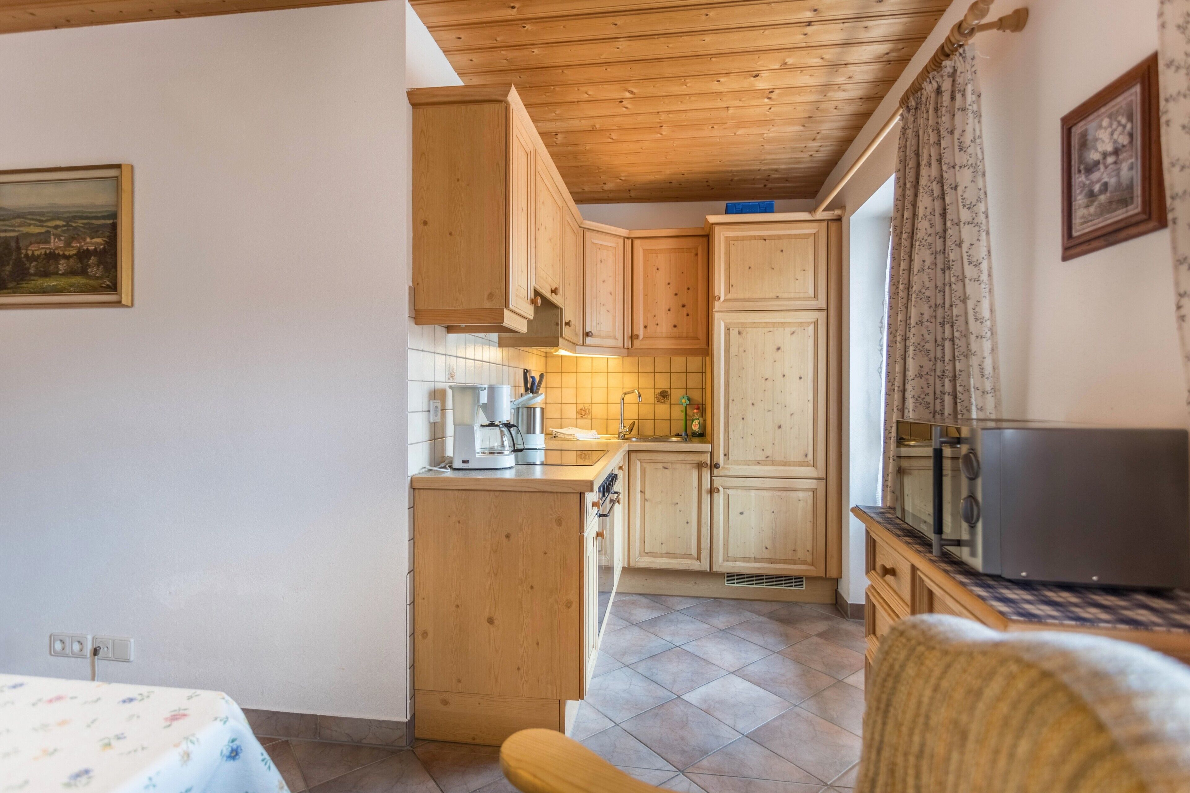 Una cucina con mobili in legno, un forno a microonde e una macchina del caffè.