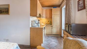 Una cucina con mobili in legno, un forno a microonde e una macchina del caffè.