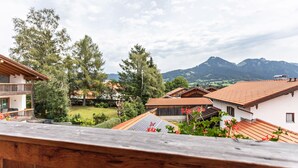 Un barrio residencial con casas, una terraza de madera y una montaña al fondo.
