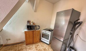 A small kitchenette with a microwave, coffee maker, and stove.