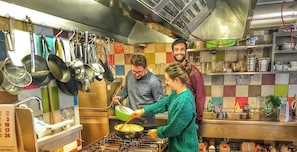A kitchen with stainless steel appliances, hanging utensils, and a tiled backsplash. - Holiday Apartment "Apartment 2" with Garden & Wi-Fi (Burghaslach)