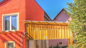 A red building with a wooden gate and a number 23 sign.